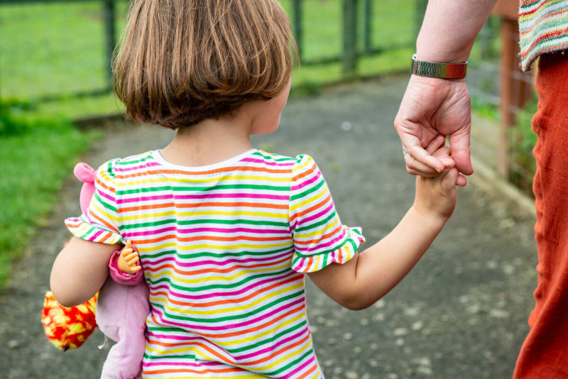 Child holding hands with a volunteer